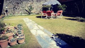 AbbottabadUrban Lodge的庭院配有桌椅和盆栽植物