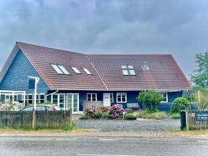 勒维Rørvig Bed & Kitchen的蓝色房子,有棕色的屋顶