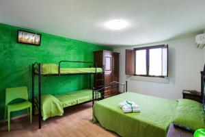 Collepasso佩拉德尔苏德住宿加早餐旅馆的一间卧室设有两张双层床和绿色的墙壁