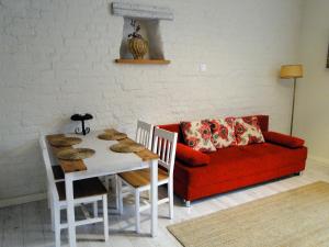 奥尔什丁Kawalerka w centrum Starego Miasta的客厅配有红色的沙发和桌子