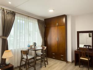 胡志明市Hoang Yen Hotel - Phu My Hung的客厅配有桌椅和镜子