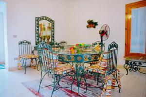 Qaryat at Ta‘mīr as Siyāḩīyah4 bedrooms villa with private pool in Tunis village faiuym的餐桌、椅子和镜子