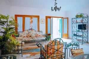 Qaryat at Ta‘mīr as Siyāḩīyah4 bedrooms villa with private pool in Tunis village faiuym的客厅配有沙发和椅子
