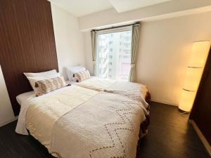 札幌パークアベニュー中島的一间卧室设有一张大床和一个窗户。