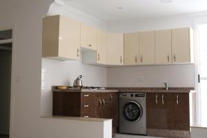 纳祖尔Apartment Hay Arrid Nador قرب فران دبي的厨房配有白色橱柜和洗衣机。