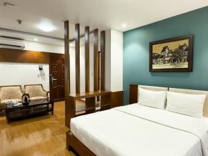 胡志明市Hoang Yen Hotel - Phu My Hung的配有一张床和一把椅子的酒店客房