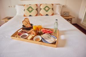 圣佩德罗-德里瓦斯Hotel Palou 1874的床上的早餐盘