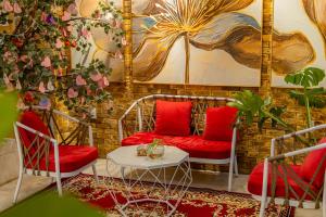 大叻Sweet Lavender Hotel - Near Dalat Night Market的一间设有两张红色椅子和一张桌子的房间