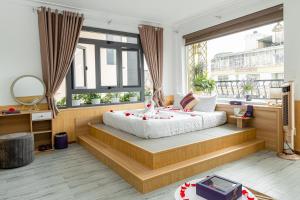 大叻Sweet Lavender Hotel - Near Dalat Night Market的一间卧室设有一张大床和一个大窗户