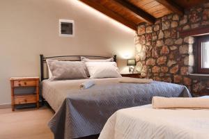 阿彻奇洛斯Petronas Land House 2的一间卧室设有两张床和石墙