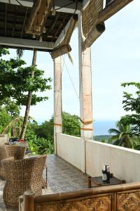 曼巴豪The balcony of the camiguin island的一个带椅子的户外庭院,享有海景