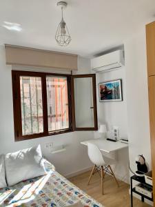 马拉加Habitación González的卧室配有一张床、一张书桌和窗户。
