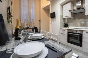 都灵[Stazione Torino Porta Susa] Grazioso Bilocale的厨房配有带白板和酒杯的桌子