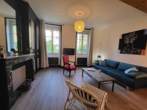 维也纳Ô Bon'Endroit - Appartement Confort - Centre Ville的客厅设有蓝色的沙发和壁炉
