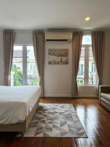 曼谷Entire 3BR Townhome in Sukhumvit, shared Pool, near BTS&MRT Asok的一间卧室配有一张床、一张沙发和窗户。