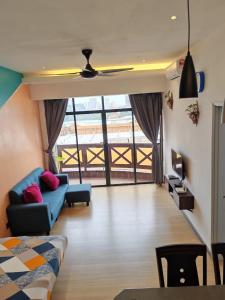 马六甲Homestay Melaka at Mahkota Hotel - unit 3093 - FREE Wifi & Parking的客厅配有蓝色的沙发和桌子