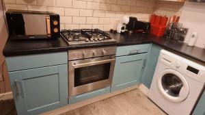 巴恩斯利Charming 1-Bed Apartment in Barnsley的一间带炉灶的厨房 洗衣机旁的顶级烤箱