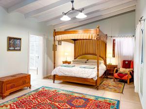 Arico ViejoExquisite rural house with garden, pool and sea views的一间卧室配有木制天蓬床和地毯。
