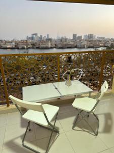 迪拜Dubai NorthStar Hostels的阳台上配有一张白色的桌子和两把椅子
