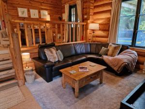 阿尔弗斯顿Newland Valley Log Cabins的客厅配有真皮沙发和茶几