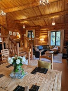 阿尔弗斯顿Newland Valley Log Cabins的小木屋内带桌子的客厅