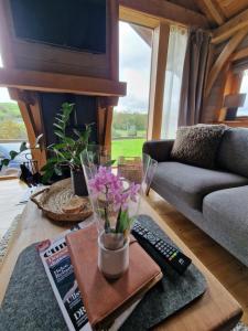 阿尔弗斯顿Newland Valley Log Cabins的客厅配有沙发和鲜花桌