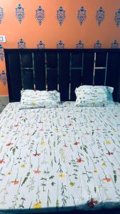 瓦拉纳西Tandon Lodge的床上配有被子和枕头