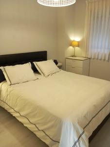 马德里Madrid Las Tablas apartments的卧室配有白色大床和灯