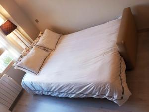 马德里Madrid Las Tablas apartments的一张带白色床单和枕头的床