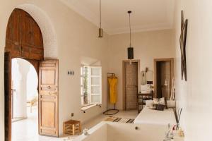 马拉喀什Riad La Lumière d'Étoile的一间带浴缸和开放式门的客厅
