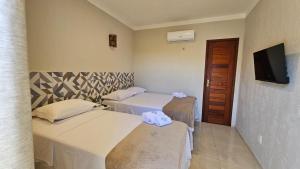 AmontadaVilla Recanto do Mar - Icaraizinho de Amontada的酒店客房设有两张床和电视。
