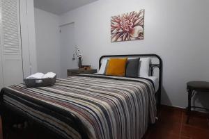 Casa Rosairis的一间卧室配有一张床,床上有条纹毯子