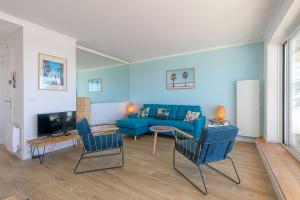 拉波勒Vue sur mer La Baule Moana的客厅配有蓝色的沙发和椅子