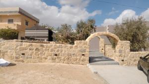 Al KhuraybahWadi Al-Nakhil Hostel的建筑前方有拱门的石墙