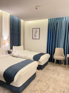 安曼Rival Hotel Amman的两张位于酒店客房的床,配有蓝色窗帘