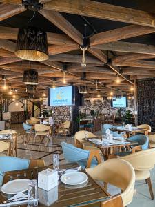 安曼Rival Hotel Amman的一间带桌椅和电视的餐厅