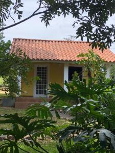 卡瓦坎特Pousada Recanto da Mata的红色屋顶的黄色小房子