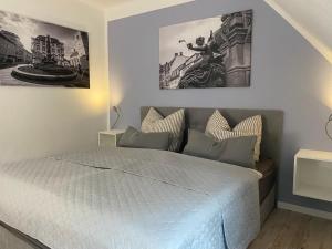 爱尔福特M.C. Apartment Erfurt Südpark的卧室配有一张墙上有两张照片的床。