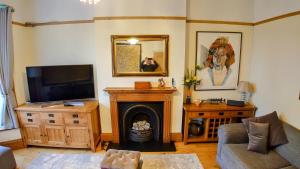 贝克斯希尔Gorgeous 4-Bed House in Bexhill-on-Sea sea views的客厅设有壁炉和电视。