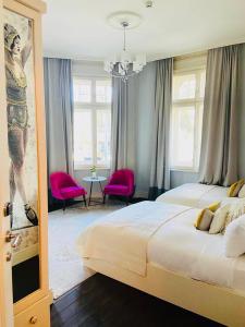普罗夫迪夫29A Guesthouse的一间大卧室,配有两张床和粉红色的椅子