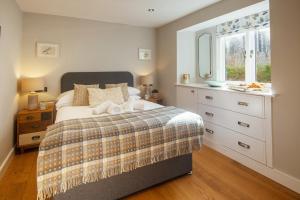 达特茅斯1 Castle Mews的一间卧室配有带梳妆台和窗户的床。