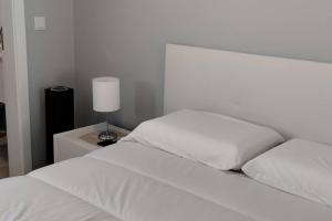 滨海保尔'A Bucha' by The Cliff Coast的一张带白色床单的床和一张桌子上的台灯