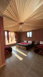 瓦迪拉姆Wadi Rum Star Camp的大房间设有两张床和天花板
