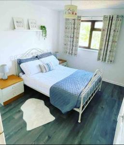 波斯考尔Coastal Corner的一间卧室配有一张带蓝色毯子的床和窗户。
