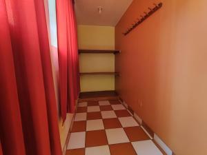 瓦拉斯Sunrise Guest House的走廊上设有红色窗帘和 ⁇ 板地板