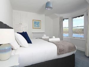 达特茅斯Dartmouth Cottage - River and Sea Views with Parking Permit的白色的卧室设有一张大床和一个窗户