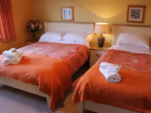 基拉卢Blossom Hill Bed and Breakfast的一间卧室配有两张带毛巾的床