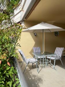 罗马Stanza Eur Tintoretto的庭院配有桌椅和遮阳伞。