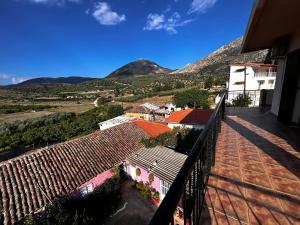 MykinesSunny house at ancient Mycenae, close to Nafplio!的阳台,位于山间房屋的背景中