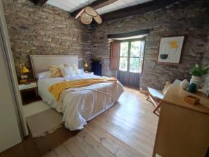 Caboalles de AbajoLa Escondida的一间卧室设有一张大床和砖墙